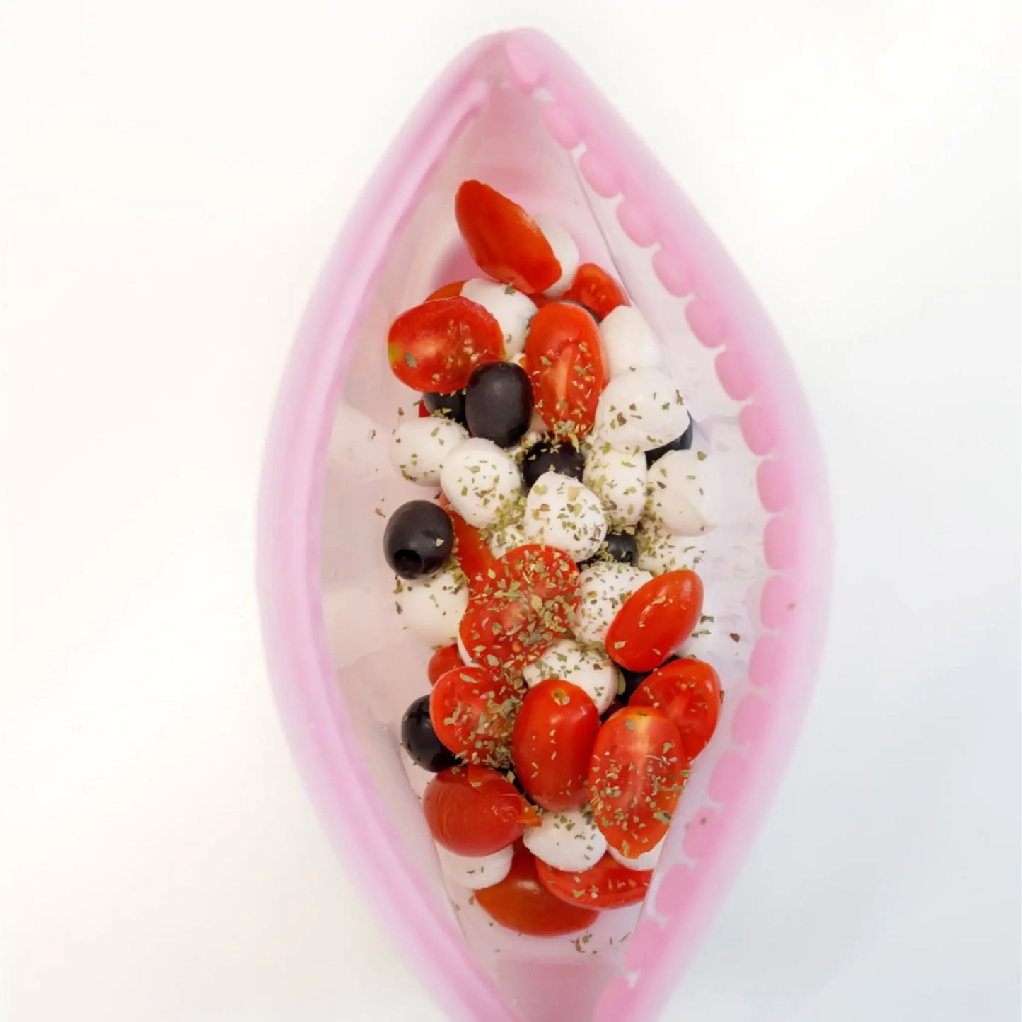 Bolsa de silicona hermética reutilizable con ensalada de tomates cherry, aceitunas y mozzarella